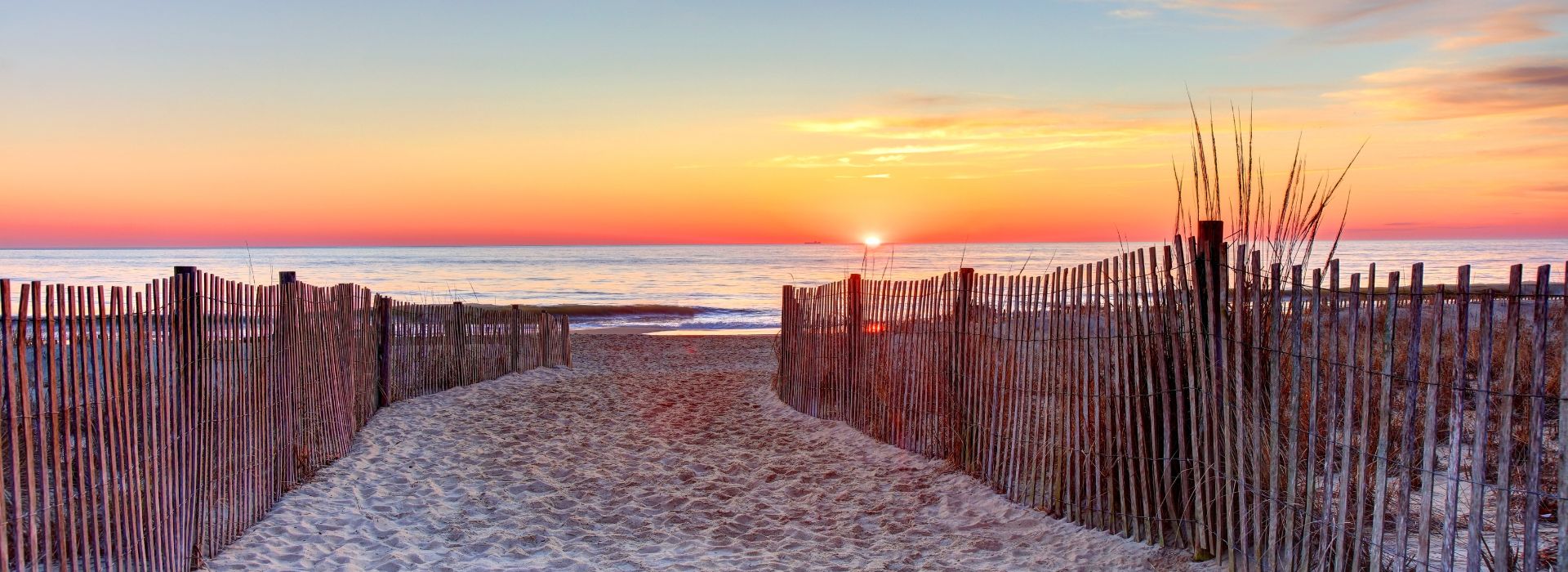 Sandy walkway to the beach overlooking a brilliant sunset over Rehoboth beach 