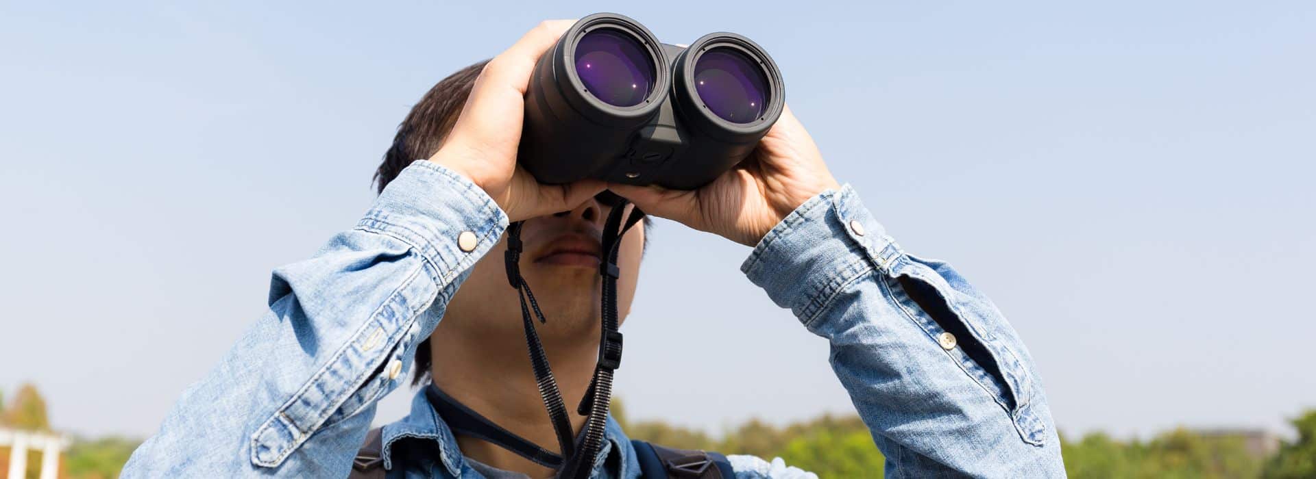 a birdwatcher looking through binoculars