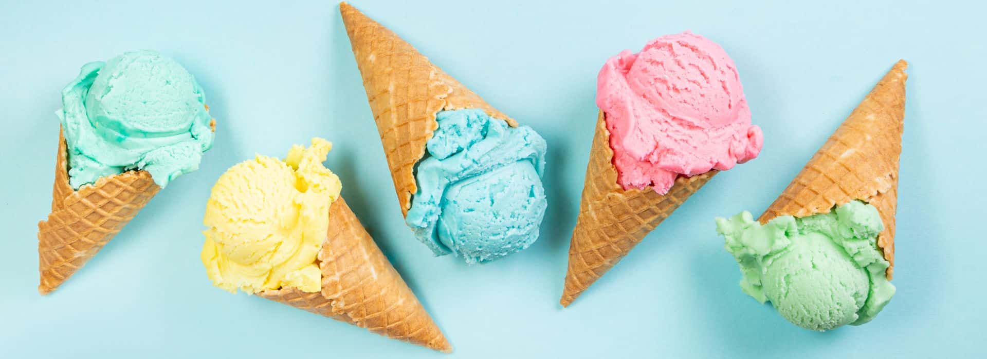 Row of waffle cones with different colored ice cream