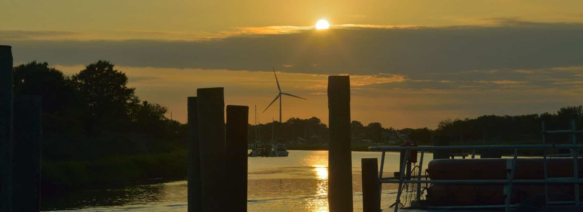Sunset over Lewes DE marina with wind turbine in the background