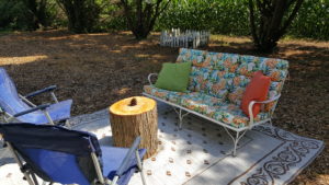 Metal Couch with Flower cushions and two blue chairs 