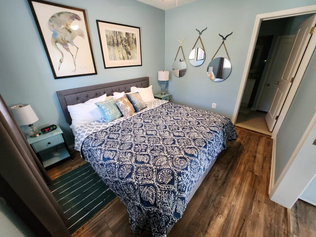 King bed with navy. Light blue walls