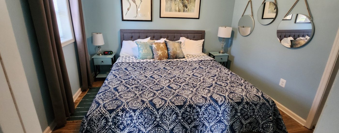 navy blue spread with sea shells, three mirrors on wall