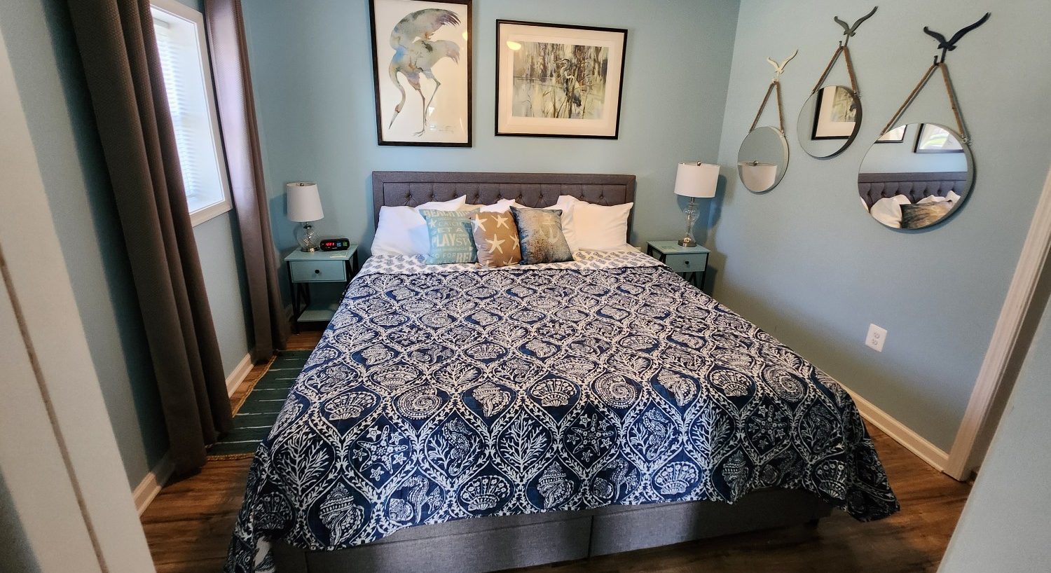 navy blue spread with sea shells, three mirrors on wall