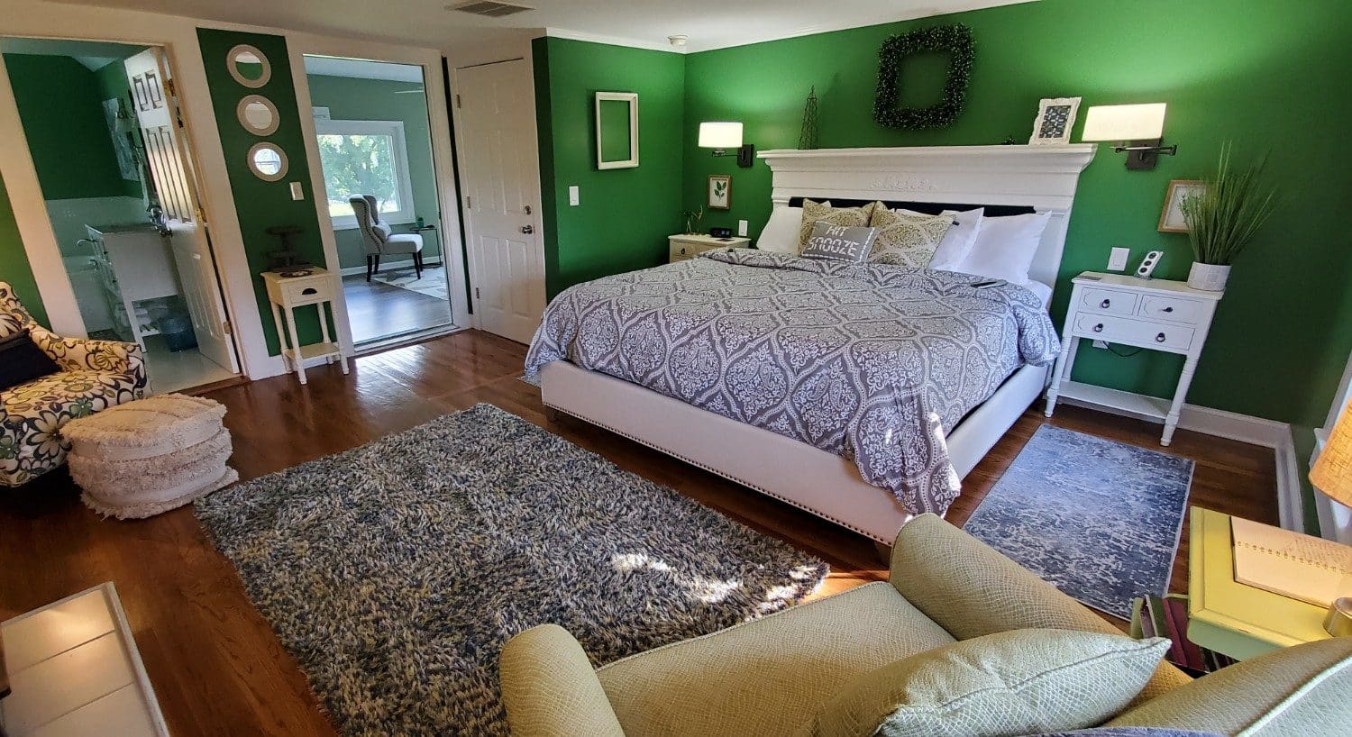 Dark green walls, hardwood floors white headboard