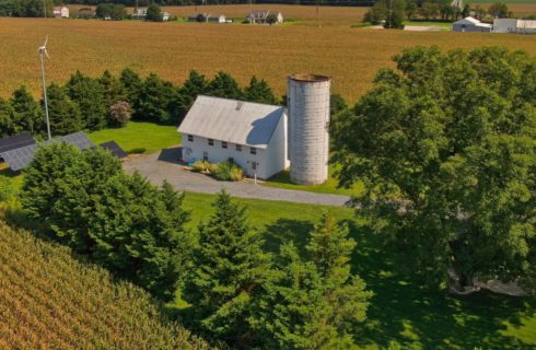 drone shot of the white barn with a white silo