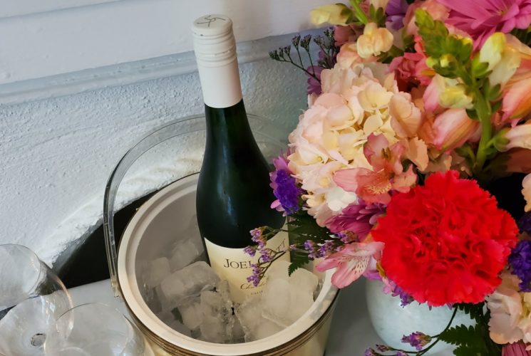 vase with mixed color flowers and a bottle of red wine