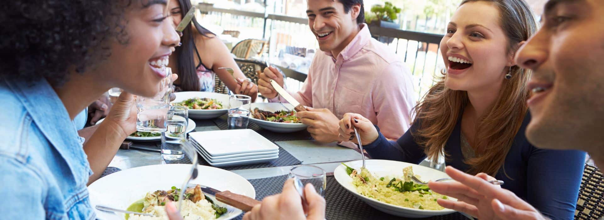 a group of friends eating outside at a restaurant